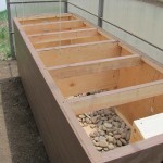 Heat collected in SunnyTherm’s solar panels is ducted into a “rock-box” heat bank in Joanne Lederhos’s high-altitude greenhouse. The stones store heat from the sun and release it after dark.  