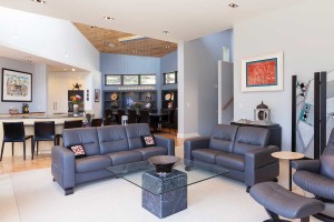 The open living room features the couple’s collection of eclectic art, including a Buddha head and a glass screen. Shelves in the background hold the Linsleys’ ceramic creations—fish, decorative plates, vases and other objects. 