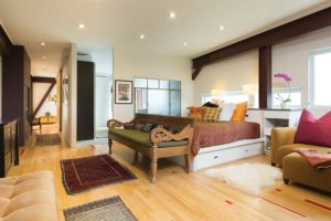 The master suite has “peepholes” above the bed so Lieff can sneak a peek of the surrounding 35 wooded acres beyond the windows at any time. The bathroom behind the glass divider has a Japanese soaking tub and indoor and outdoor showers. (photo by Paul Weinrauch)