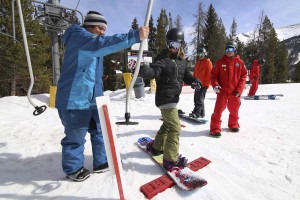 Instructors get a young snowboarder pointed in the right direction.
