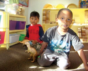 Two preschoolers spend some free time playing with dinosaurs. (Photo by Emma Smith)