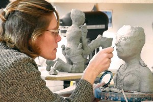 Ceramic sculptor Janis Wunderlich is another of the artist mothers who tell their stories in Who Does She Think She Is? The female figures in her work are often loaded with more children than anyone could take care of. (photo by Mystic Artists)