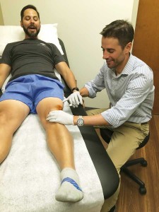 Dr. Jason Glowney, right, works with a patient at CU’s Sports Medicine and  Performance Center. (photo courtesy Jason Glowney)