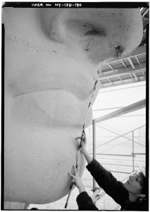 After a century of unmitigated corrosion, the Statue of Liberty had developed cracks, scabs, stains, holes and “rust boogers”—here investigated by architectural historian Isabel Hill in March 1985. (photo by Jet Lowe, courtesy Library of Congress, Prints & Photographs Division, Historic American Engineering Record) 