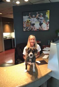 Bug helps Kathi Fischer welcome visitors to Boulder’s Peaksware, where dogs join meetings and company events. (photo courtesy Peaksware)