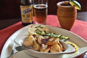 Camerones flameado — wild, jumbo Gulf shrimp—are served with rice, asparagus and tequila flambé. (photo by Phil Mumford)